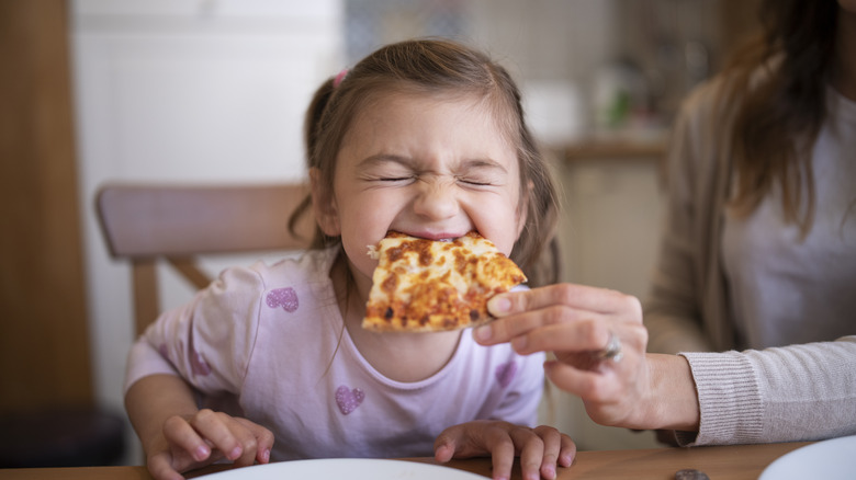 Little girl eating pizza slice