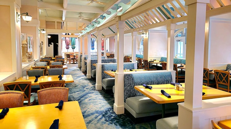 The pink and blue interior of Cape May Cafe in Disney's Beach Club Resort with tables and booths