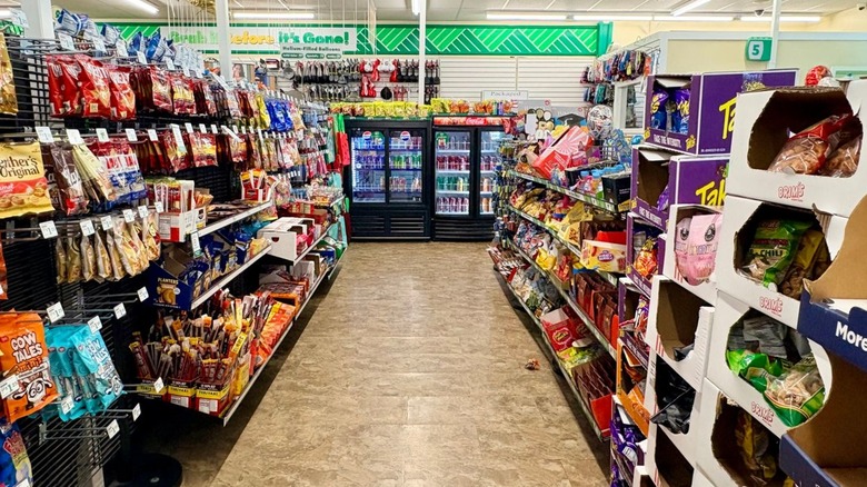 A Dollar Tree checkout aisle lined with snacks and chilled drinks