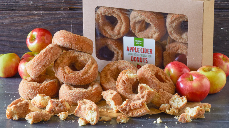 Pile of apple cider donuts next to box and donuts