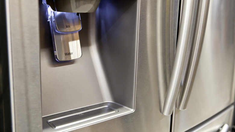 A refrigerator door water dispenser