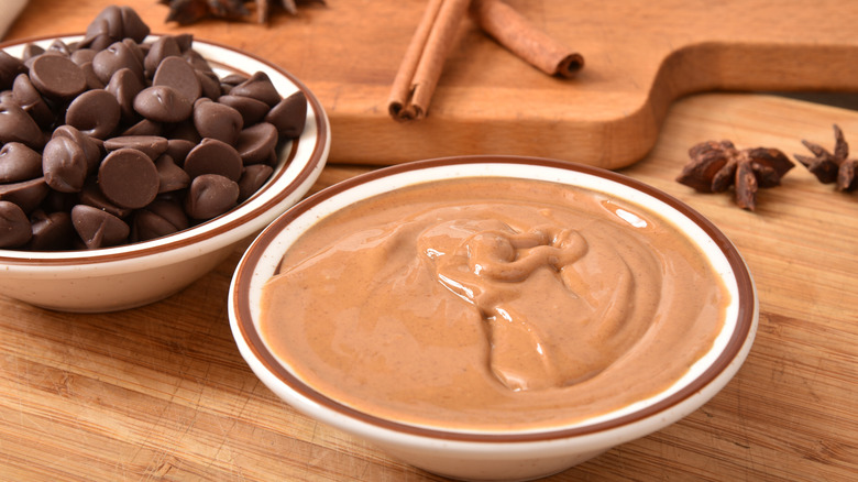 Bowl of peanut butter next to bowl of chocolate chips