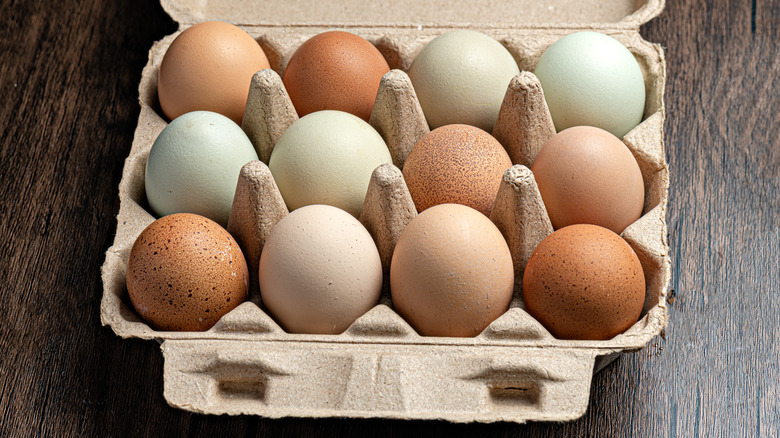 A carton of a dozen white and brown eggs