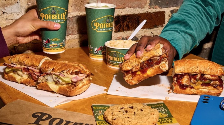 Potbelly sandwiches, sides, and drinks on a table with people out of frame