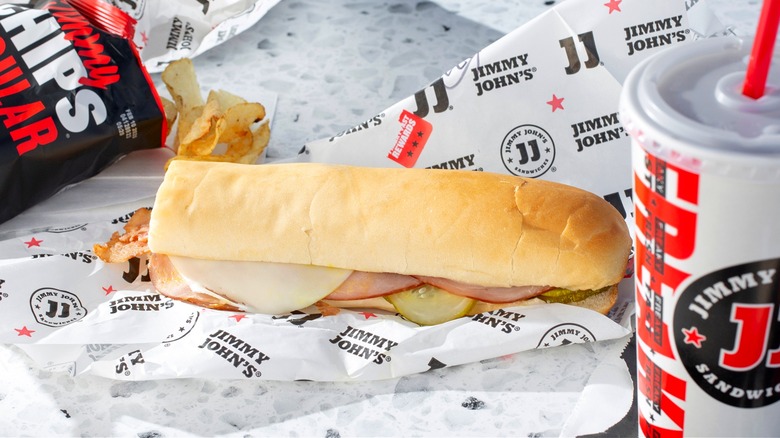 Jimmy John's sandwich, chips and drink on paper wrapper