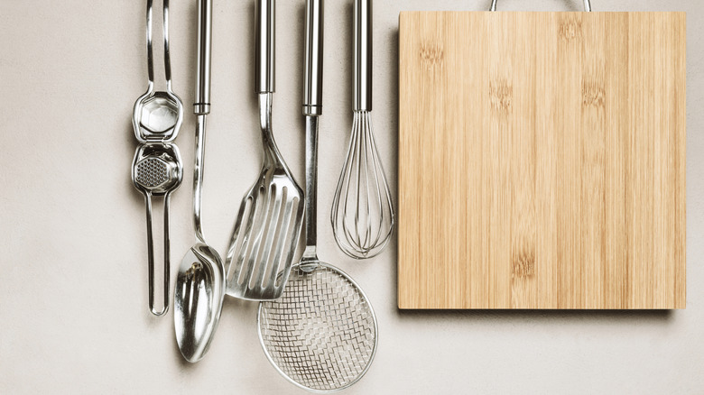Metal cooking utensils hanging on a kitchen wall