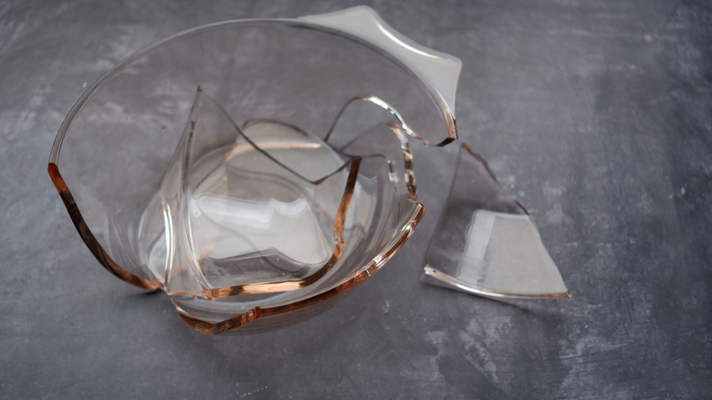 A broken clear Pyrex bowl with a large piece off to the side