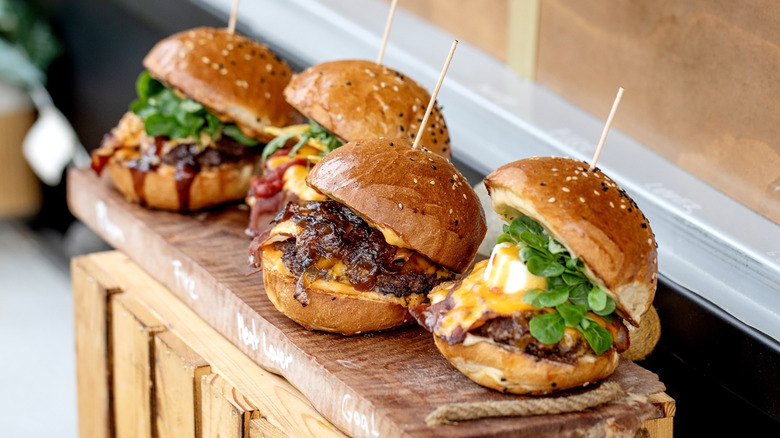 Four sliders placed on a wooden board