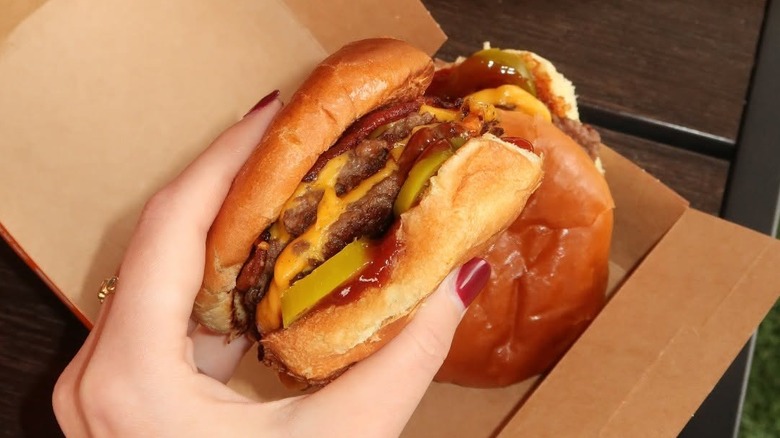 A person holding a slider from Smalls Sliders