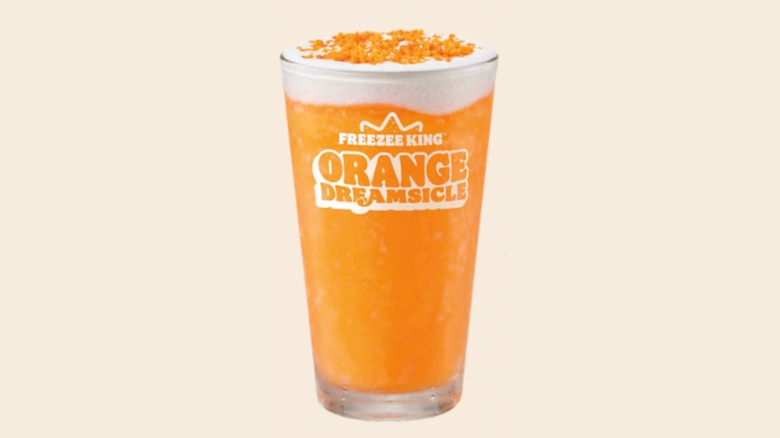 An Orange Dreamsicle Freezee King in a pint glass that says that