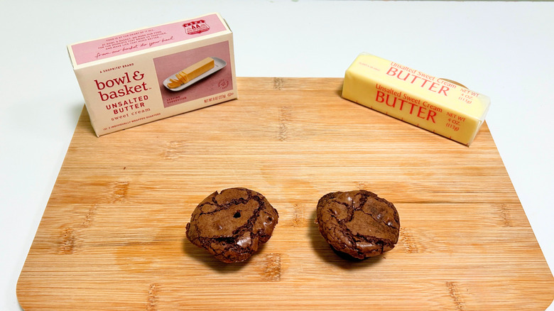 A box of Bowl and Basket Unsalted Butter next to a stick of butter and two brownie bites