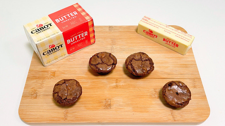 A box of Cabot Creamery Sweet Cream Unsalted Butter next to a stick of butter and four brownie bites
