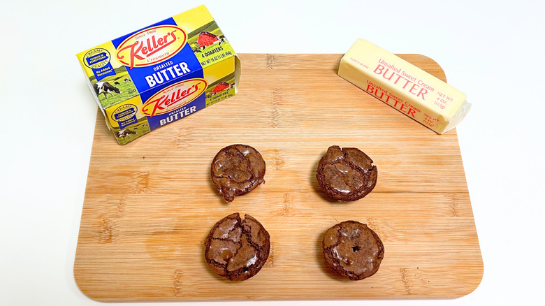A box of Keller's Creamery Unsalted Butter next to a stick of butter and four brownie bites