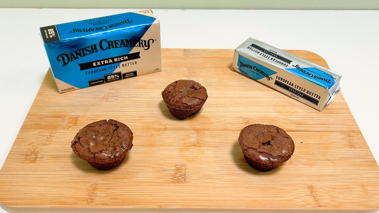 A box of Danish Creamery Extra Rich European Style Butter next to a stick of butter and three brownie bites