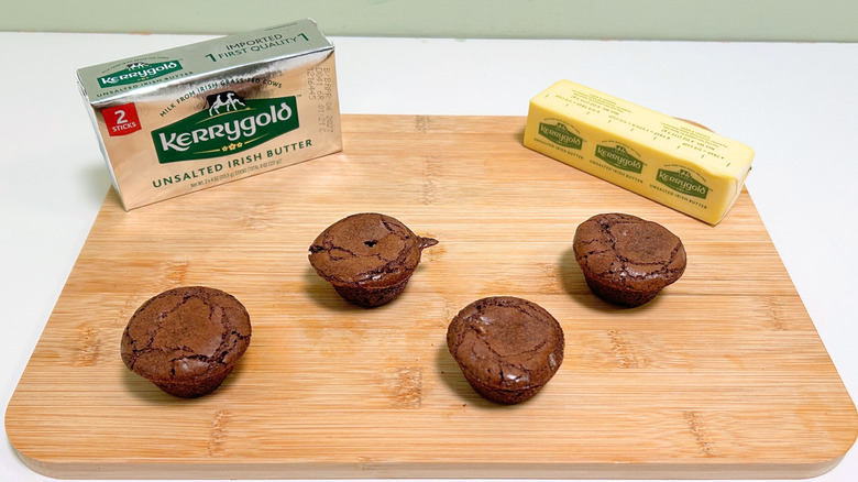 A box of Kerrygold Unsalted Irish Butter next to a stick of butter and four brownie bites