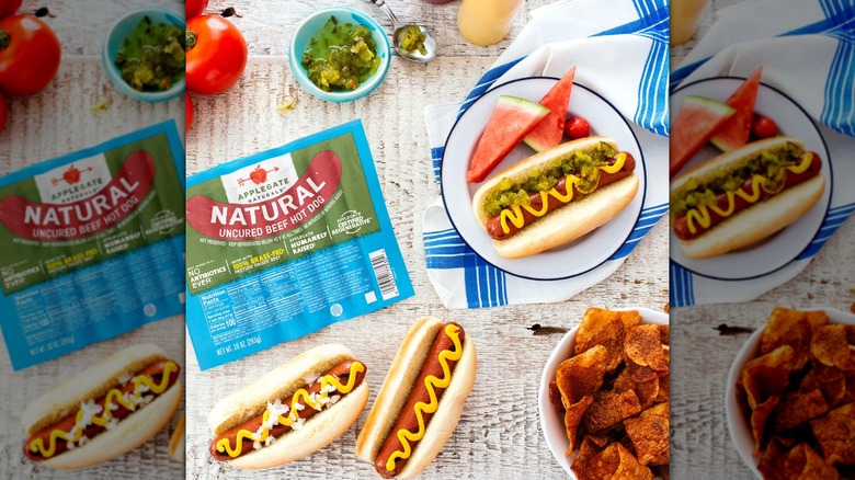 Applegate Natural Uncured Beef Hot Dogs on a table, dressed with mustard and other condiments