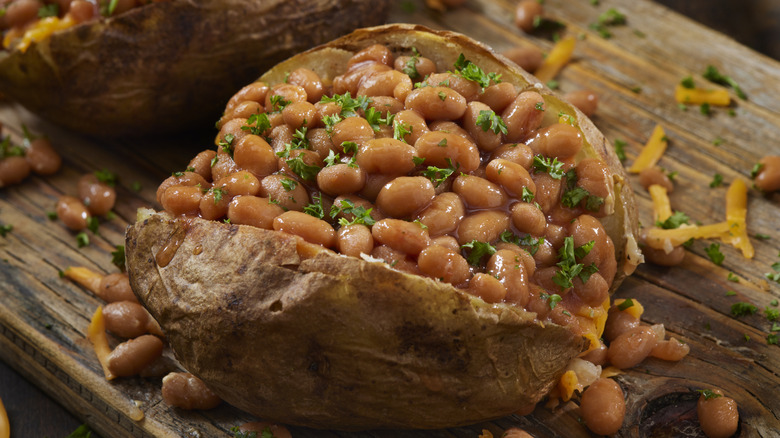 Baked potato with beans, cheese, and a chopped parsley garnish