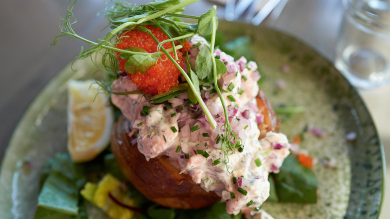 Baked potato with shrimp, caviar, and greens