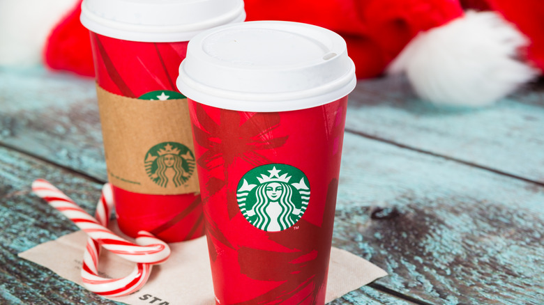 Starbucks peppermint mocha inside a red holiday cup next to candy canes
