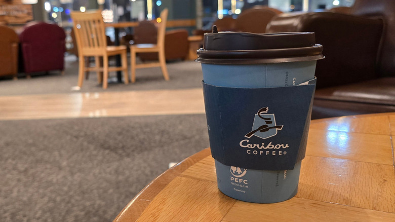 A small paper cup of Caribou Coffee