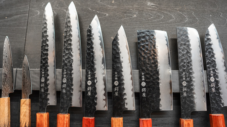 Set of Japanese knives with wood handles on magnetic holder