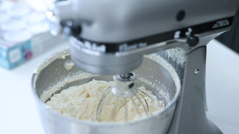 Homemade whipped cream in a silver KitchenAid stand mixer
