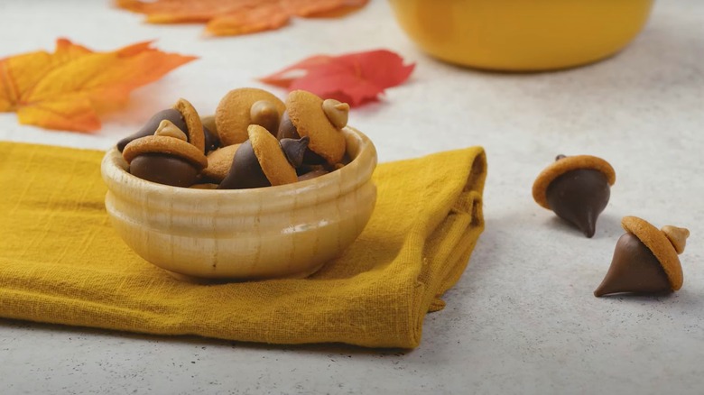 A bowl of acorn cookies made of Hershey Kisses, vanilla wafers, and peanut butter chips