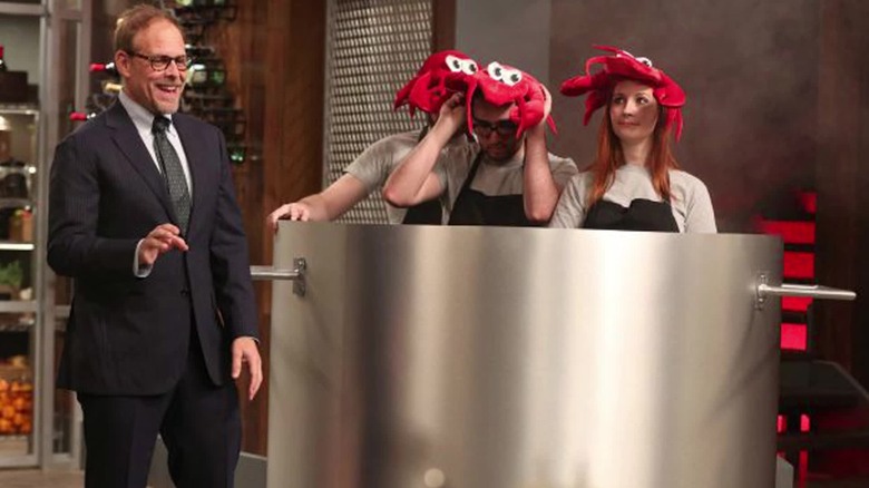 Alton Brown with three chefs in a pot with lobster hats