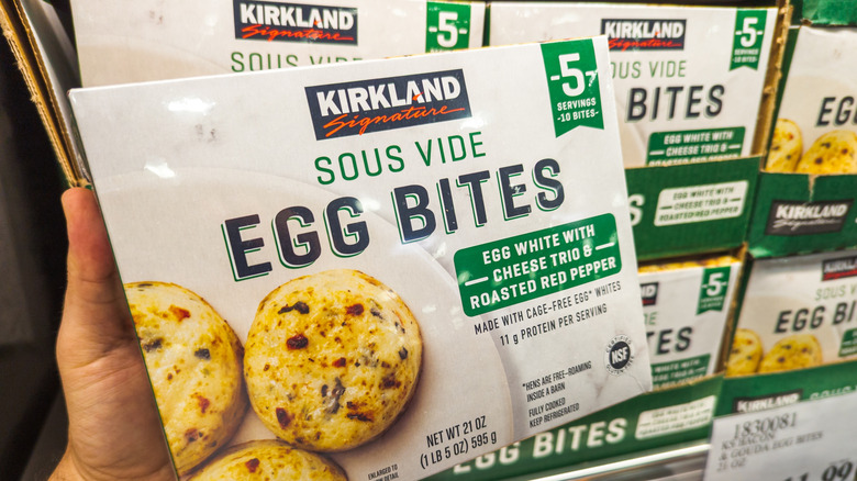 A hand holding a Kirkland egg bites box
