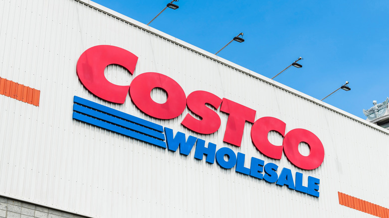 A Costco sign on the outside of a warehouse building during the day