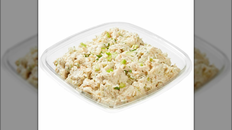 Costco chicken salad in a plastic container on a white background