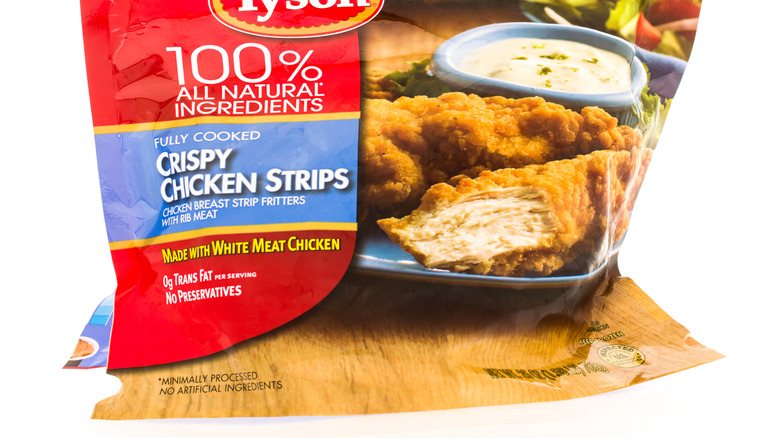 A close-up of a bag of Tyson crispy chicken strips on a white background