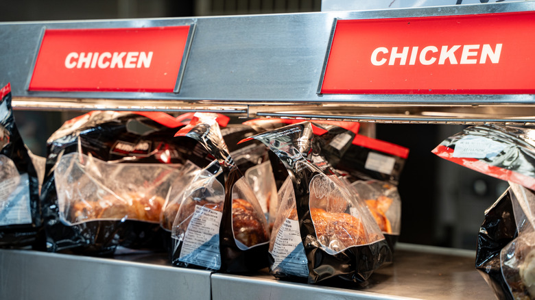 Costco rotisserie chickens in bags under heat lamps