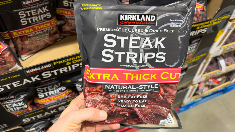 Hand holding Kirkland Steak Strips