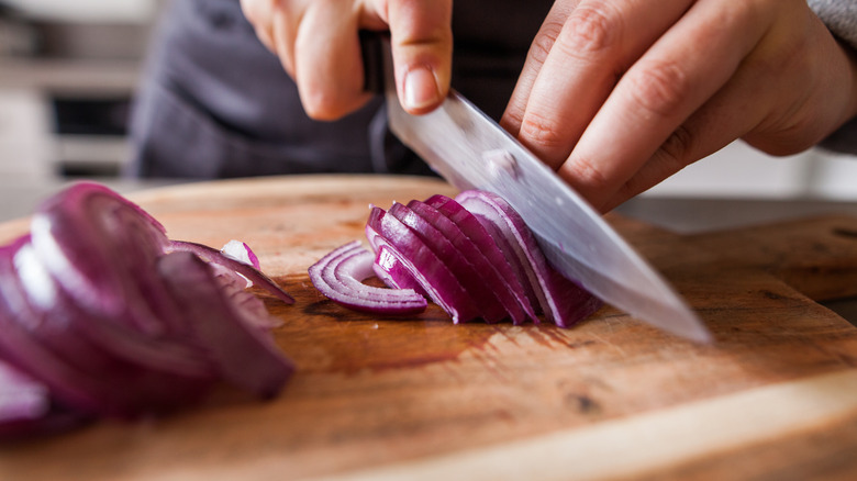 Hand cutting red onion