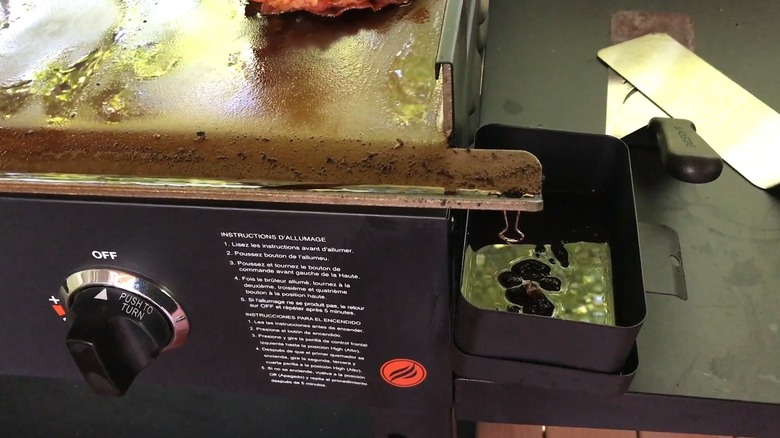 Dirty grease trap on a Blackstone griddle