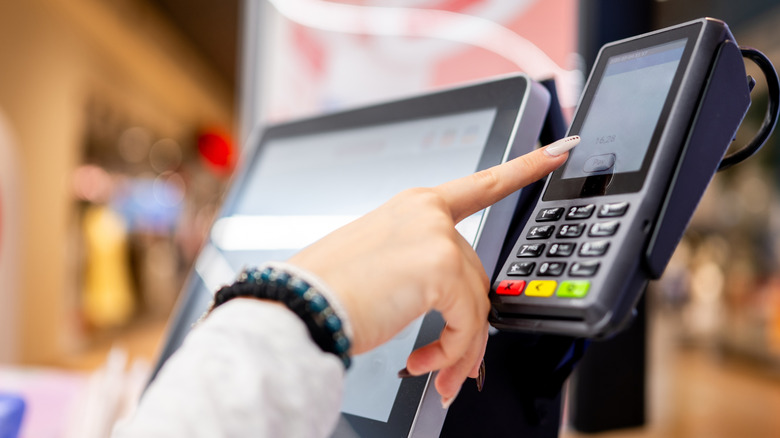 Finger about to press "Pay" at the grocery self checkout