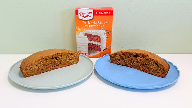 A box of Duncan Hines Perfectly Moist Carrot Cake Mix next to two plates of cake