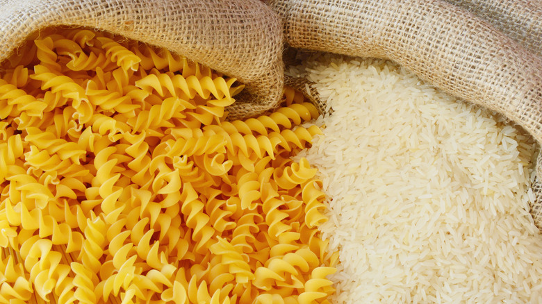 Close-up of rotini pasta and white rice in canvas sacks