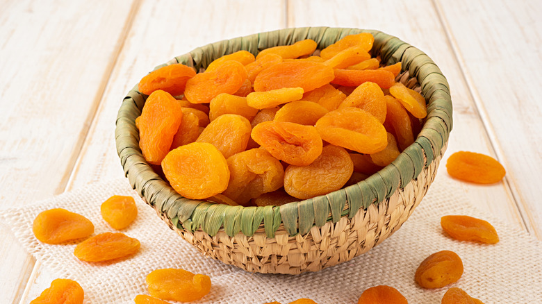 A bowl of dried apricots placed on a table.