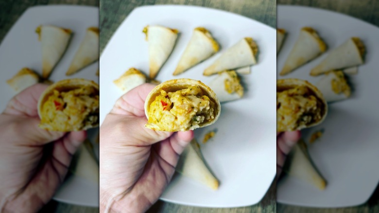 Hand holding quesadilla cone with filling