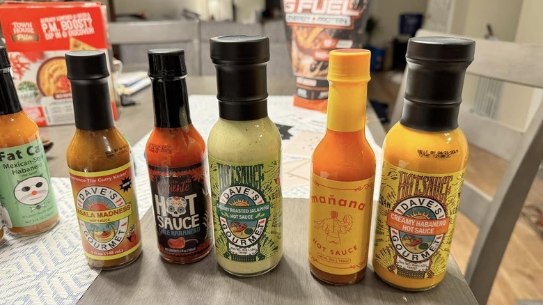 Hot sauce bottles lined up on table