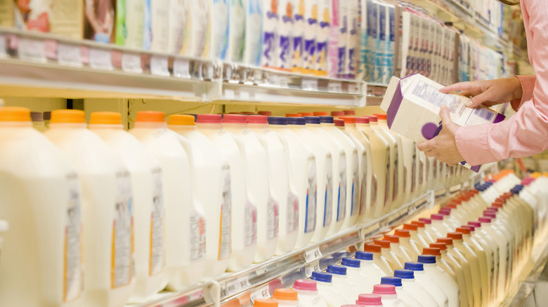 Woman checking date on milk carton