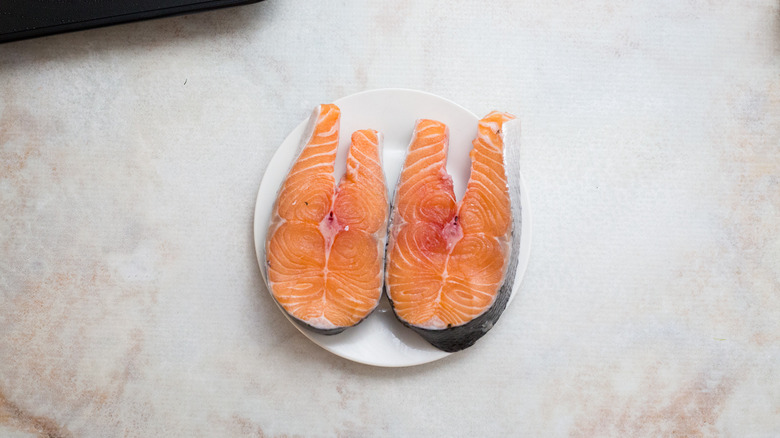 raw salmon steaks on plate