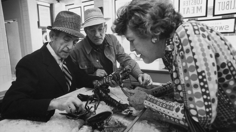 Julia Child picking lobsters with two gentlemen in hats