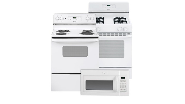 Two plain white range/oven units and one plain white microwave