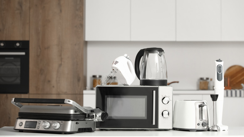An assortment of stainless steel or white kitchen appliances on a kitchen counter