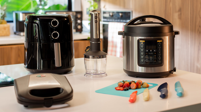 A selection of kitchen gadgets and small appliances on a white kitchen counter
