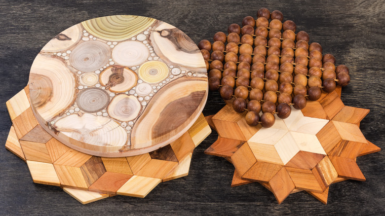 Several wooden trivets in assorted patterns and shapes