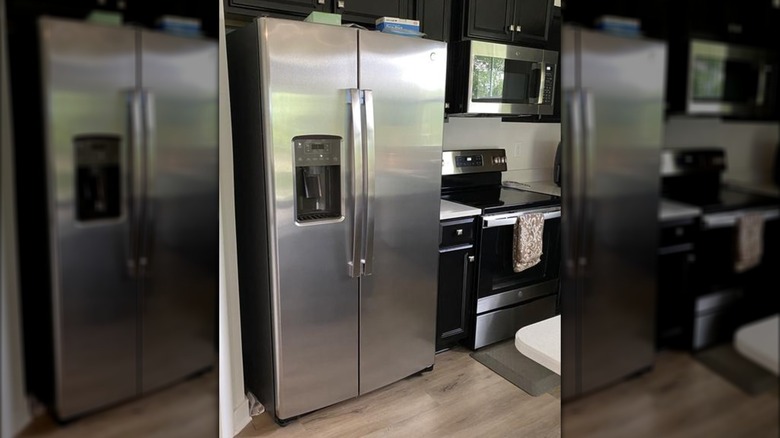 A stainless steel GE refrigerator with full length side by side doors and an exterior ice maker